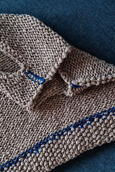 a close up of a knitted sweater on a blue surface