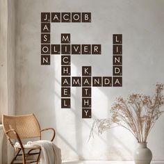 a chair sitting in front of a white wall with scrabble tiles on it