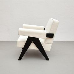 a white and black chair sitting on top of a gray floor