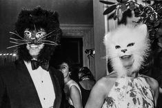 two people dressed up as cats and one is wearing a cat's head mask