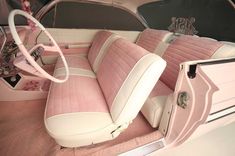 the interior of a pink and white car