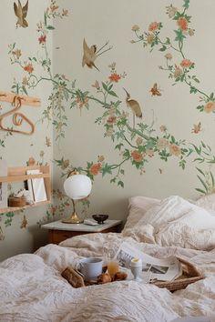 a bed with flowers and birds painted on the wall