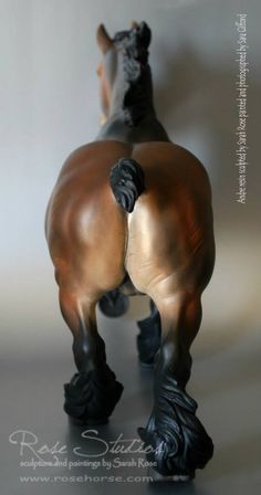 a bronze statue of a horse with its back turned to the camera, on a white background