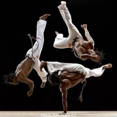 three men performing acrobatic tricks in front of a black background at the circus