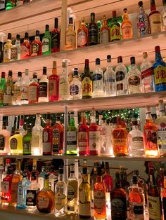 many bottles of alcohol are lined up on the shelves