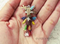 a hand holding a tiny toy animal in it's palm with other small items