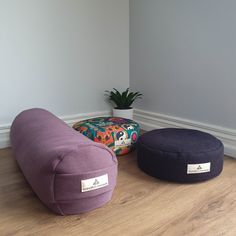 three bean bags sitting on the floor next to a potted plant in a corner