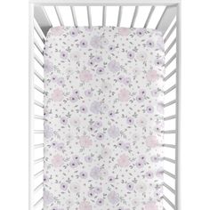 a white crib with pink and purple flowers on the side, in front of a white background