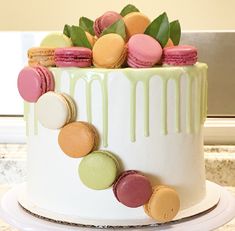 a decorated cake with macaroons and leaves on top