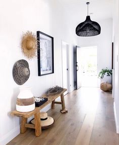 a wooden bench sitting on top of a hard wood floor next to a white wall