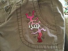 a pair of khaki pants with pink and white designs on them