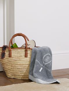 two baskets are sitting on the floor next to each other with towels and sunglasses in them