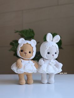 two crocheted stuffed animals standing next to each other on a white counter top