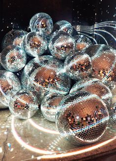 a pile of shiny disco balls sitting on top of a floor next to each other