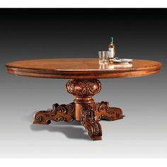 an ornately carved table with a wine bottle on it's top and two glasses in the middle