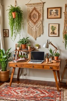 a wooden desk topped with a laptop computer sitting next to potted plants on top of a rug