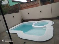 an empty swimming pool in the middle of a backyard