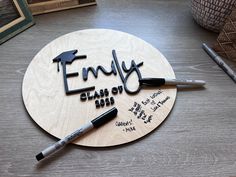 a wooden plaque with writing on it that says family class of 2013 and two markers