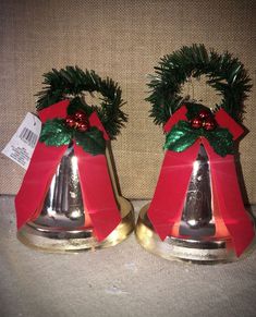 two bells with christmas decorations on them sitting next to each other