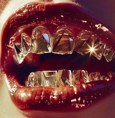 a woman's mouth is covered in ice cubes and shines red lipstick