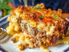 a piece of lasagna with meat and cheese on a blue and white plate