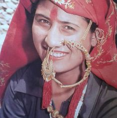 a woman with a nose ring and red scarf on her head