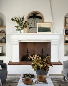 a living room filled with furniture and a fire place in front of a white fireplace