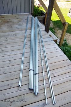 four metal poles laying on top of a wooden deck