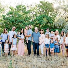 a large family is posing for a photo in the grass with their two children and one adult