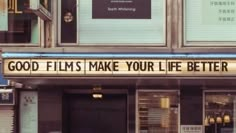 a sign that says good films make your life better on the side of a building