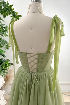 the back of a dress with green ribbons on it