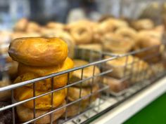 a bunch of doughnuts stacked on top of each other in a display case