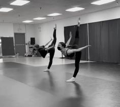 two women doing yoga poses in an empty room