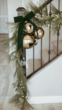 christmas decorations on the banister with bells and greenery