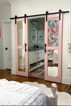 a bedroom with pink sliding doors and white furniture