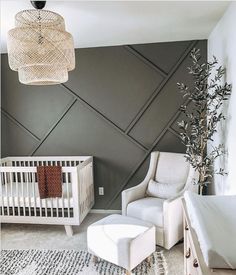 a baby's room with grey walls and white furniture