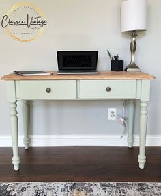 a desk with a laptop on it and a lamp in the corner next to it