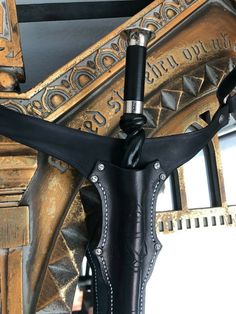 a close up of a black leather umbrella with metal decorations on the top and bottom