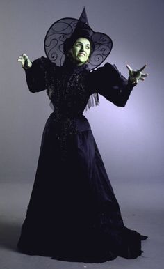 a woman in a witch costume with her hands out