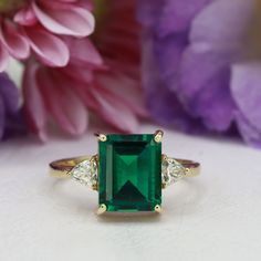 This handmade emerald ring is a true work of art, featuring a stunning octagon cut emerald gemstone that is beautifully complemented by two trillion-shaped moissanites (or simulated diamonds, depending on the metal). The emerald's deep green hue is breathtaking, and its octagon cut adds a unique and eye-catching dimension to the ring. The moissanites (or simulated diamonds) set on either side of the emerald add just the right amount of sparkle, creating a truly mesmerizing piece of jewelry. Insp Rectangle Emerald Ring, Ring Rectangle, Rectangle Ring, Green Ring, Green Rings, May Birthstone, Knot Ring, Wire Wrapped Rings, Onyx Ring