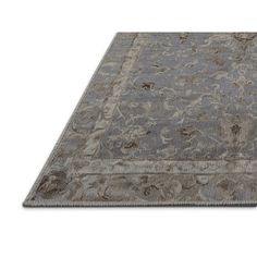 a gray rug with an intricate design on the top and bottom, in front of a white background