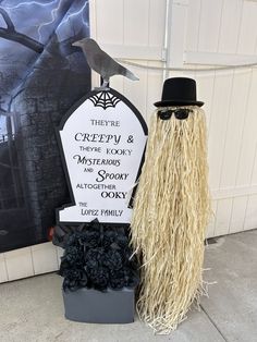 there is a tombstone with a hat and long hair next to a fake crow on it