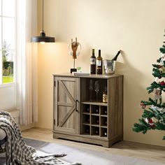 a wooden cabinet with wine bottles and glasses on it in front of a christmas tree