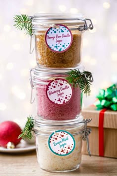 three glass jars filled with different types of seasoning next to a christmas ornament