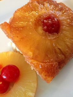 two pieces of pineapple on a plate with cherries