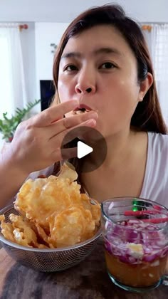 a woman sitting at a table with food in front of her and a bowl of coleslaw