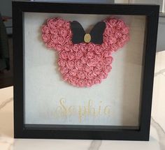 a shadow frame with a mickey mouse made out of pink roses