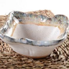 a white bowl sitting on top of a wicker place mat next to a basket