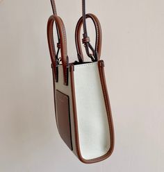 The latest brand “Frances Tote Bag” of B’s ​​Pure Original is made of selected canvas and topstitched leather, and is decorated with Thomas Burberry’s exclusive logo. Wear it in the hand or carry it with the detachable strap. Sized to accommodate iPhones of all sizes. Size: 13 x 7.5 x 18cm White Shoulder Bag With Leather Trim For On-the-go, Luxury Brown Canvas Bag With Detachable Handle, Beige Coated Canvas Bag With Detachable Handle, Canvas Bucket Bag With Shoulder Strap, Rectangular Coated Canvas Bucket Bag With Handles, Brown Canvas Bag With Detachable Handle, Canvas Shoulder Bag With Handle Drop For Daily Use, Rectangular Canvas Bag With Handle Drop For Daily Use, Trendy Leather Shopping Bag