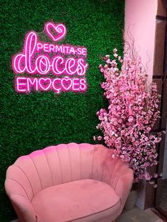 a pink chair sitting in front of a green wall with the words'fermitas dolces emoces'on it